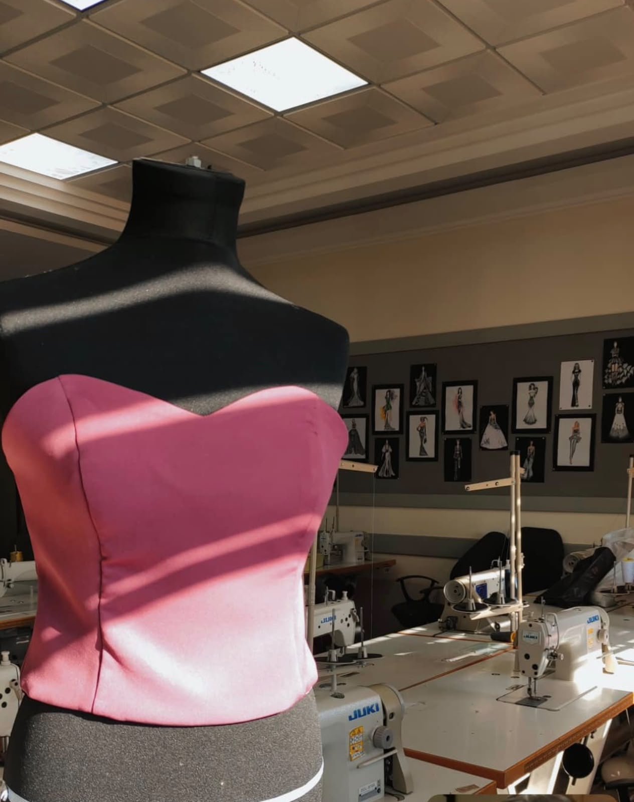 Pink corset on a dress form in the atelier